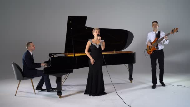Dívka zpívá v trojici muzikantů — Stock video