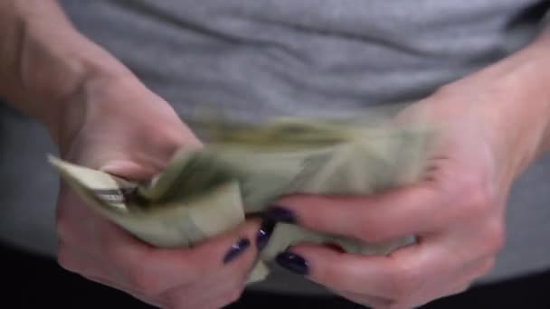 A menina considera notas de dólar em um fundo preto — Vídeo de Stock