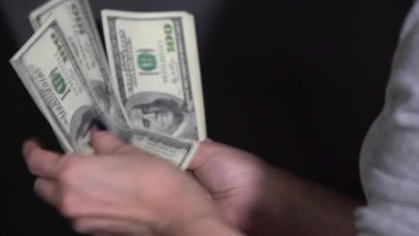 Het meisje beschouwt dollarbiljetten op een zwarte achtergrond — Stockvideo