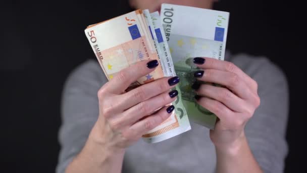 La fille considère les billets de dollar sur un fond noir — Video