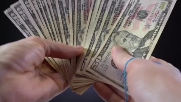 Un paquete de billetes de dólar atados con una banda elástica — Vídeo de stock