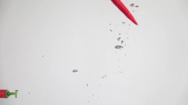 Acı biberler suya düşüyor. Yavaş çekim