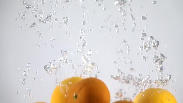 Oranges tombant dans l'eau. Mouvement lent 