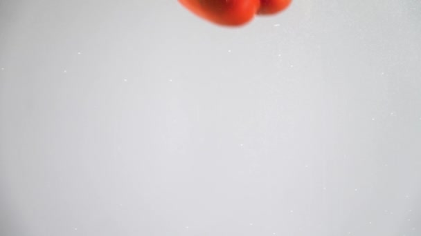 赤唐辛子は水の中に落ちる。スローモーション — ストック動画