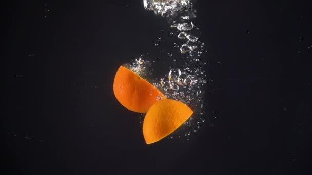 Tangerines falling into the water. Slow motion — Stock Video
