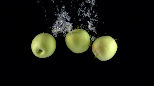 Äpplen faller i vatten. Långsamma rörelser 250fps — Stockvideo