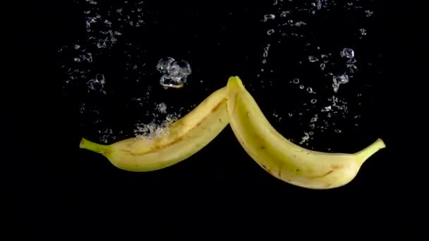 Bananen vallen in het water. Langzame beweging 500fps — Stockvideo