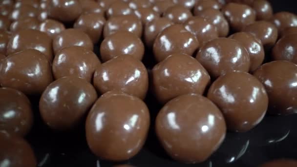 Bolas de chocolate sobre un fondo negro — Vídeos de Stock