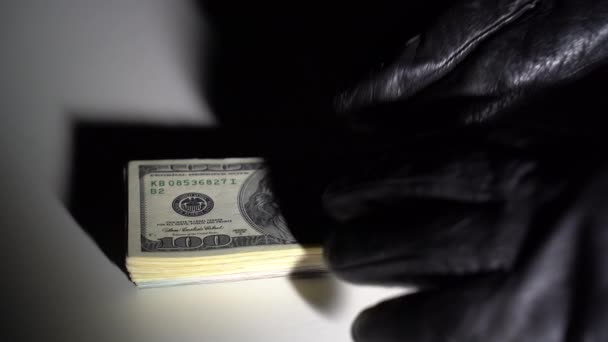 Zloděj v rukavicích ukradne balíček dolarů. — Stock video