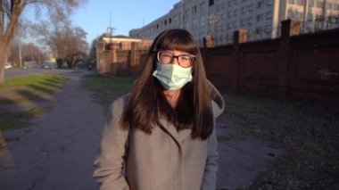 Kız şehirde maske takıyor. Yavaş çekim