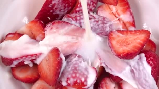 Aardbeien besproeid met melk. Langzame beweging 250fps — Stockvideo