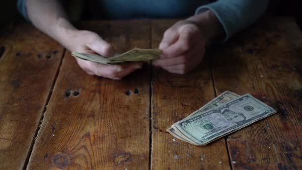 Elderly woman counts dollar bills — Stock Video