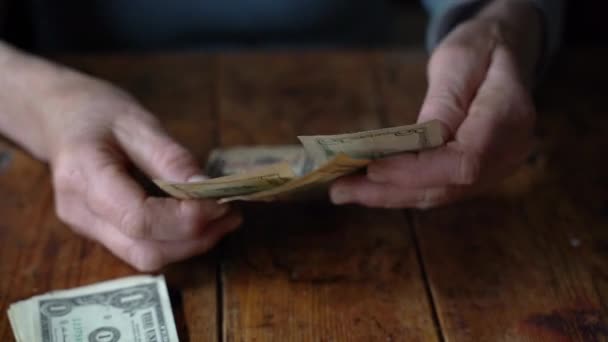 Elderly woman counts dollar bills — Stock Video