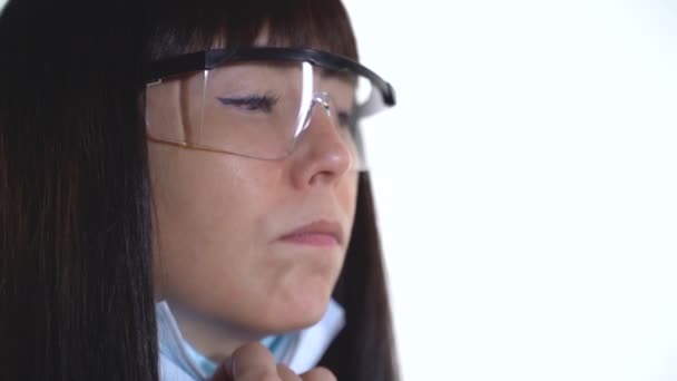 Orvosi maszkos és szemüveges nő eszik egy fánkot 500 fps — Stock videók