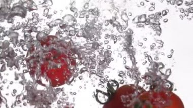 Domatesler suya düşer. Yavaş çekim 250 fps