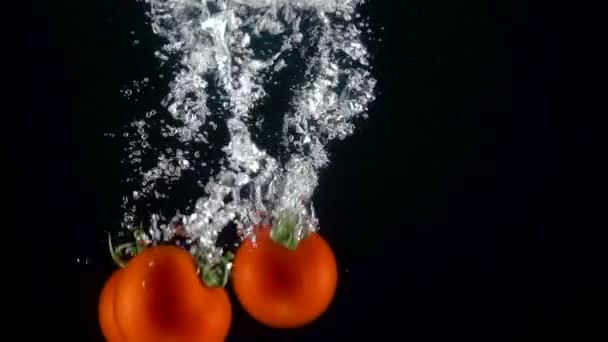 Tomaten fallen ins Wasser. Zeitlupe 250fps — Stockvideo