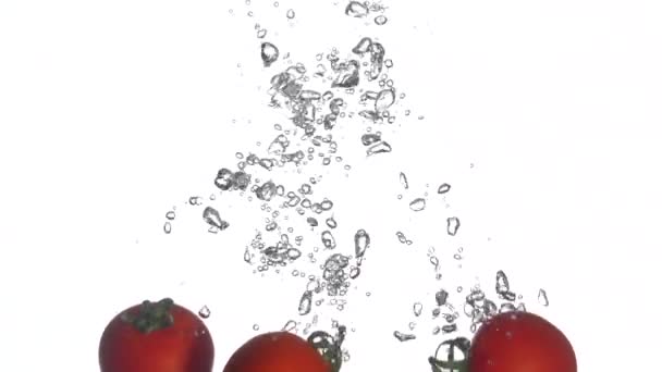Tomaten vallen in het water. Langzame beweging 250fps — Stockvideo