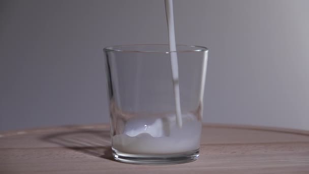 Mjölk hälls i ett glas. Långsamma rörelser 250fps — Stockvideo