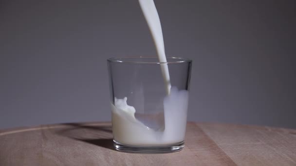 Mjölk hälls i ett glas. Långsamma rörelser 250fps — Stockvideo