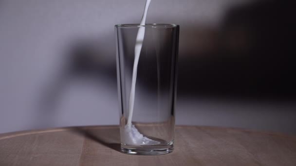 O leite é derramado em um copo. Movimento lento 250fps — Vídeo de Stock