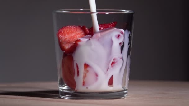 Häll mjölk på jordgubbar. Långsamma rörelser 250fps — Stockvideo
