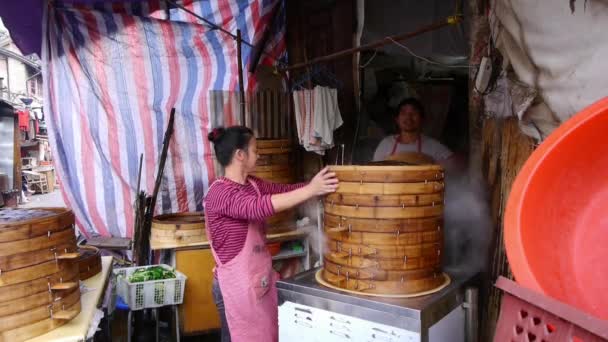 Čína, shanghai-12 září 2016: typický čínský drdol stojan, Žena počítat peníze, čerstvé housky s párou. — Stock video