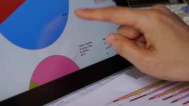 İşadamı tablet diyagramlarıyla Finans pasta grafikler dokunmadan parmak üzerinde çalışma.