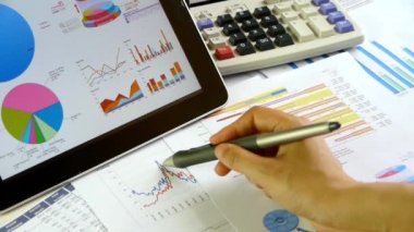 İşadamı tablet diyagramlarıyla hesaplama mali veri üzerinde çalışma.