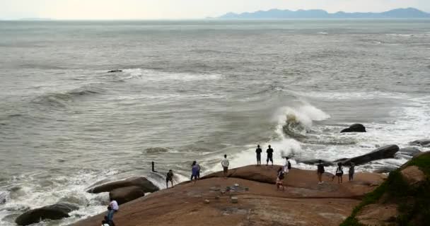 4k personas ven el mar brillante mar agitado rugientes olas en la costa rocks.coastal . — Vídeo de stock