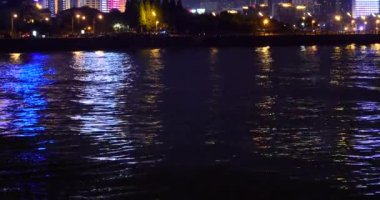 4k video, gece okyanus dalgaları, trafik ve geceleri kentsel inşaat.