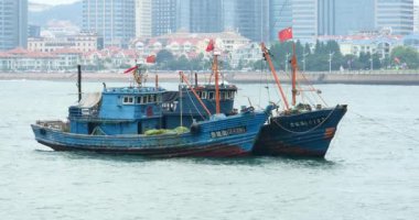 Qingdao Çin-Temmuz 12, k 2017:4 video, kentsel inşaat arka plan karşı denizde yüzen deniz araçları.