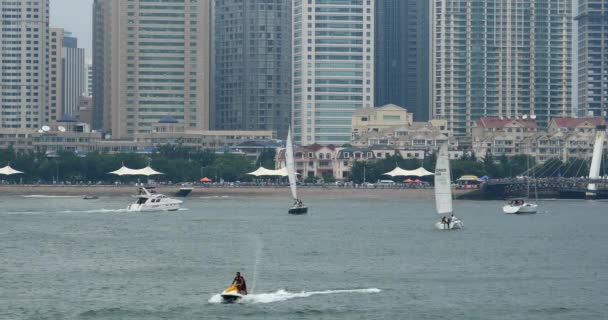QingDao China-July 12,2017:4k video,sailboats sailing in the sea against urban building background. — Stock Video