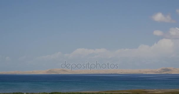 4k lejanas dunas de arena del desierto, masa de nubes hinchadas blancas rodando sobre el lago azul . — Vídeos de Stock