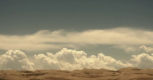 4k Zeitraffer große weiße, geschwollene Wolkenmasse, die über Wüstensanddünen rollt. — Stockvideo