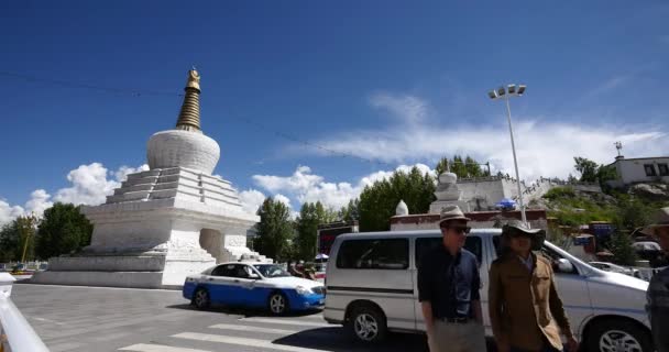 Cina-Ott 12,2016: 4k traffico occupato e pedonale attraverso stupa bianco a Lhasa, Tibet . — Video Stock