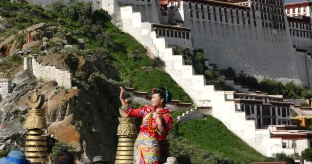 China-Ago 12,2016: 4k novia tibetana hacer una variedad de posiciones frente a potala en Lhasa, Tíbet . — Vídeos de Stock