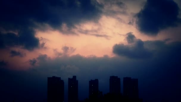 Ciel couvert de nuages sombres le soir, immeuble de grande hauteur, silhouette de la maison . — Video