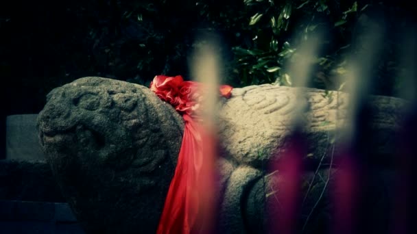 Каменная черепаха с красной лентой, жжение благовоний в горелке, ветер sm — стоковое видео
