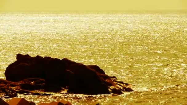 Kolsyrat vatten ytan och rock reef kustnära, horisont, skyline, sunrise, guld. — Stockvideo