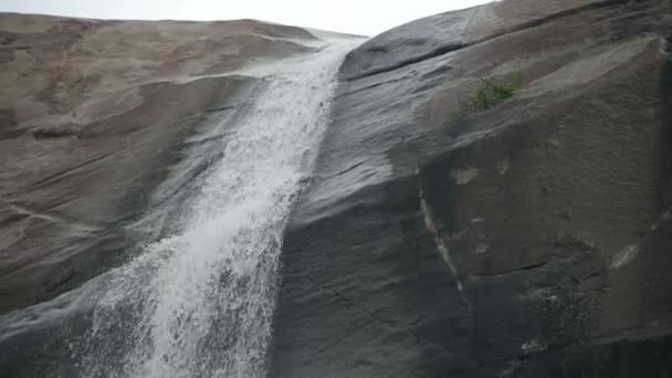 山の崖の上の滝は池の湖に流れ込み. — ストック動画