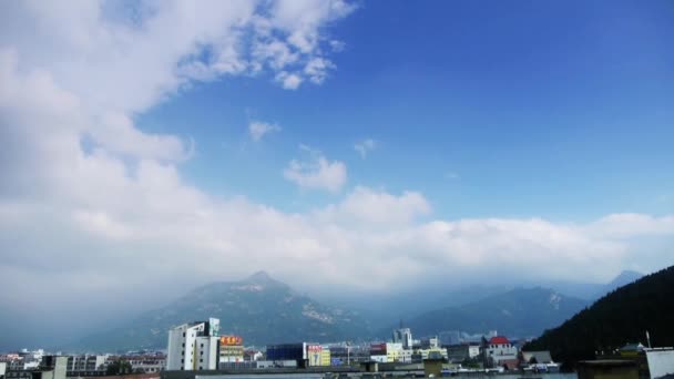 Nuages au sommet de la colline, Bâtiments municipaux proches de la montagne . — Video