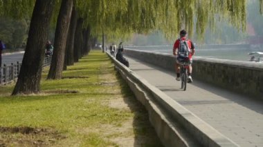 Çin-Ekim 12, göl, Pekin yasak şehir yol kenarında söğüt river.yacht dayanarak 2016:A adam binicilik bisiklet.