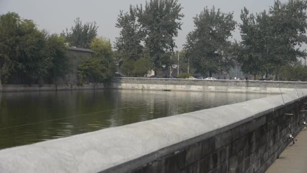 China-Oct 12,2016:fishing by sparkling moat lake relying on fence in Beijing Forbidden City. — Stock Video