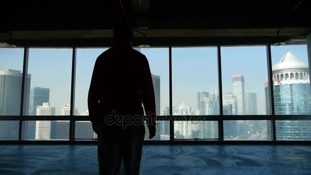 Un uomo d'affari a piedi per finestre e prospettive di business building . — Video Stock