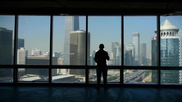 A businessman outlook business building from window. — Stock Video