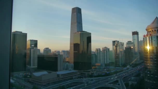 Desde la ventana del edificio para ver la arquitectura moderna al atardecer, el sol pasa a través de ganar — Vídeos de Stock