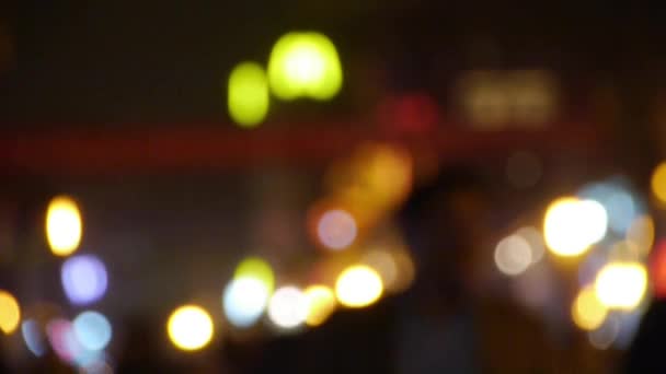 Oskärpa upptagen publiken siluett & neon ljus cirkel på business gatan nattetid. — Stockvideo