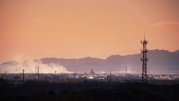 Panoráma a város & gyári füst támaszkodnak hegy, torony a hegyen alkonyatkor. — Stock videók