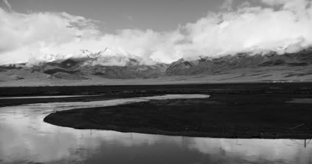 4 k timelapse wolken massa voortschrijdend over Tibet berg, rivier stroomt de prairie. — Stockvideo