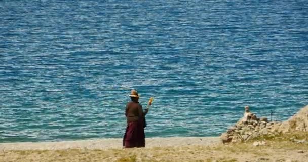 Kina-okt 12, 2016:4 k tibetaner kvinna promenader pilgrimen på den sjön nomadiska i tibet. — Stockvideo